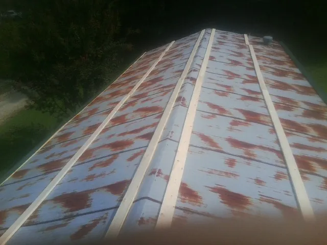 Rusted metal roof panels with new wood purlins before replacement — Storm Damage Roof Repair in Cleveland by Roofing Brothers